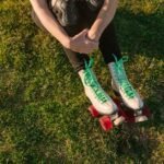 Overhead view of a person resting on grass in roller skates, enjoying outdoor leisure.