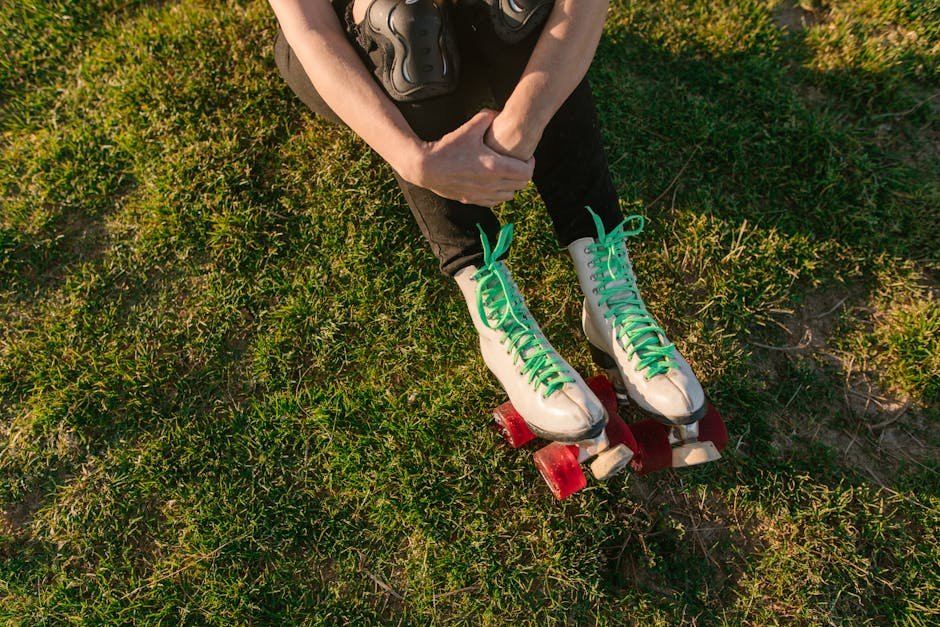 Overhead view of a person resting on grass in roller skates, enjoying outdoor leisure.